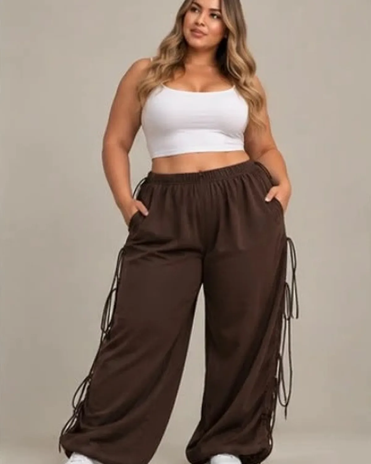 Modelo curvy con el pantalón chocolate y las manos en los bolsillos